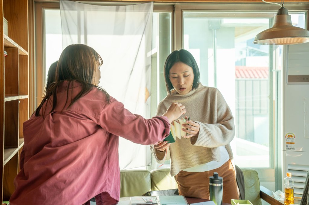 창가에서 아코디언 진을 펼쳐 보는 두 사람