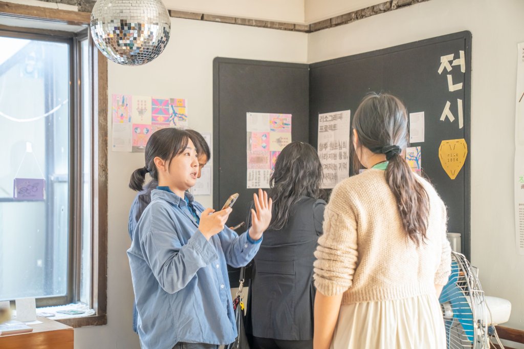 리소 전시 앞에서 이야기를 나누는 사람들