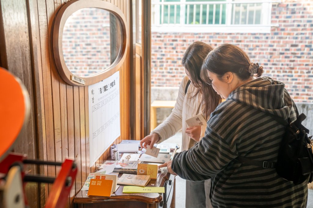 투표판 아래에서 후보 진을 고르는 두 방문객