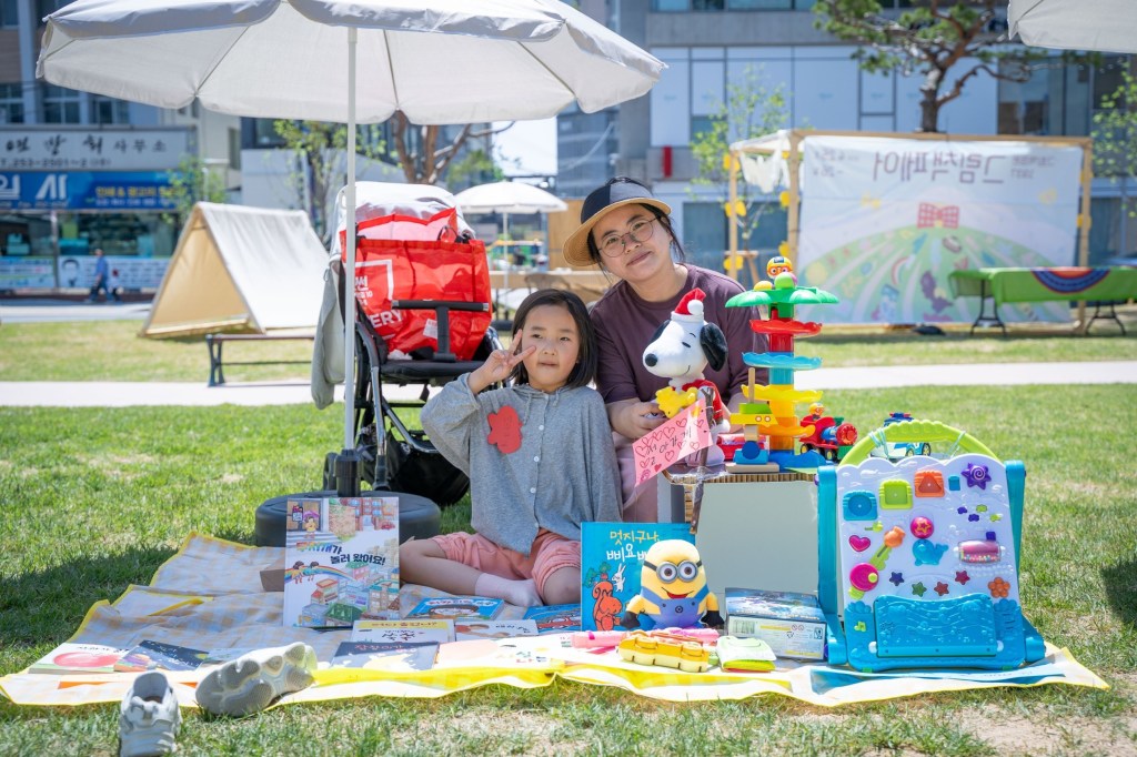 스누피 인형과 장난감, 그림책을 펼친 어린이 셀러와 엄마