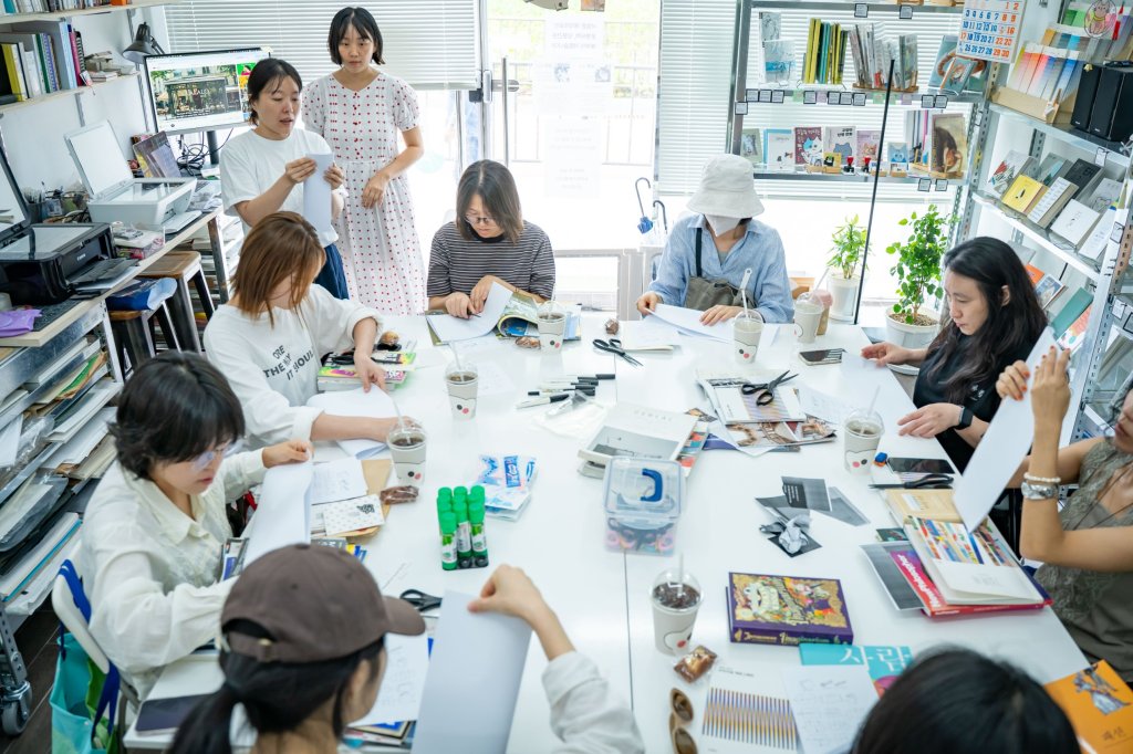 위에서 내려다본 작업 테이블 — 책과 잡지, 가위와 풀