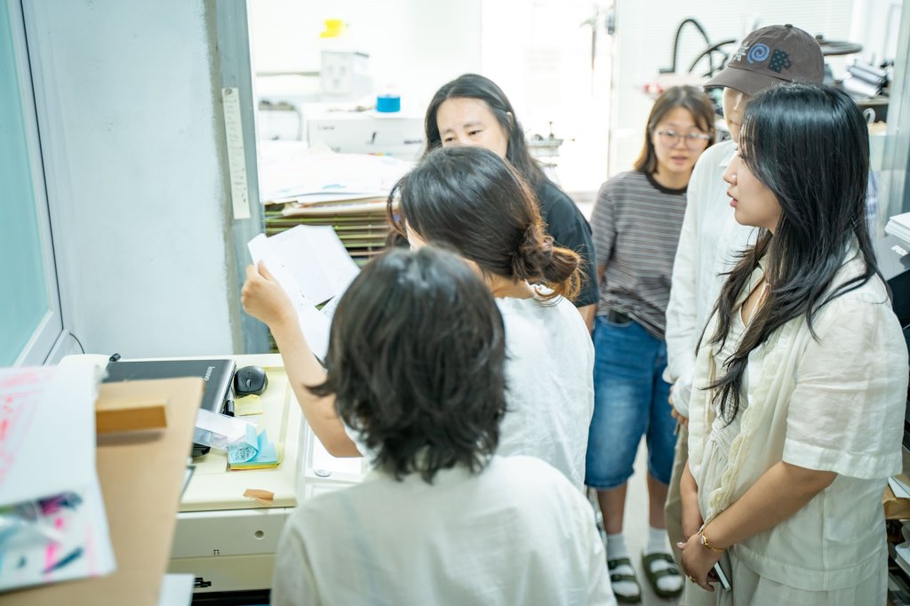 복사기 앞에 모여 출력물을 함께 살펴보는 참여자들